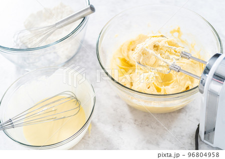 Mixing ingredients in a glass mixing bowl to bake July 4th bundt cake with chocolate stars. 96804958