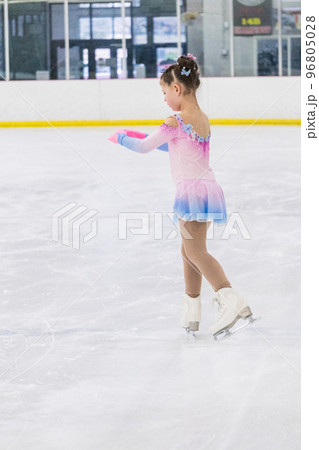 Little girl practicing figure skating on an indoor ice rink. 96805028