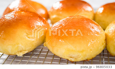 Step by step. Cooling freshly baked brioche buns on a kitchen cooling rack. 96805033