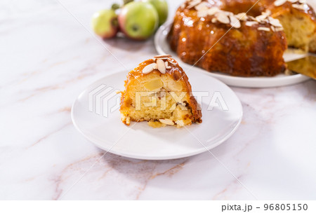 Slice of homemade apple bundt cake with caramel glaze on a plate. Slice of homemade apple bundt cake with caramel glaze on a plate. 96805150