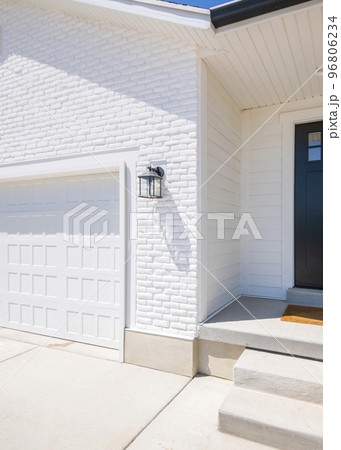 Vertical Facade of a house with white exterior and black front door with glass, doorbell camera and lockbox Vertical Facade of a house with white exterior and black front door with glass, doorbell camera and lockbox 96806234