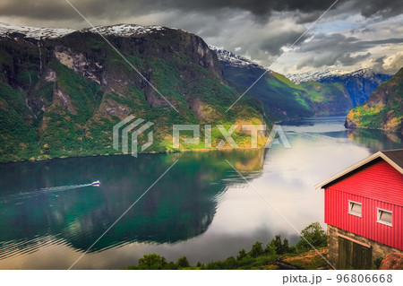 Norwegian rorbu above Aurlandsfjord with reflection and boat, Norway , Nordic Norwegian rorbu above Aurlandsfjord with reflection and boat, Norway , Nordic 96806668
