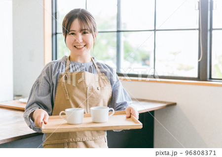 カフェ・キッチンでコーヒーを運ぶホールスタッフ・ウェイトレスのアジア人女性 96808371