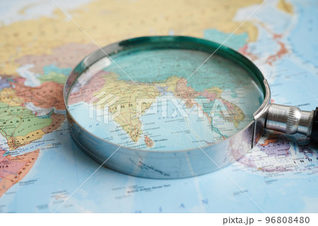 Bangkok, Thailand - May 15, 2022 Magnifying glass on world map. Bangkok, Thailand - May 15, 2022 Magnifying glass on world map. 96808480