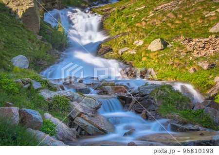 Ethereal waterfall and alpine meadows at springtime, Gran Paradiso Alps, Italy Ethereal waterfall and alpine meadows at springtime, Gran Paradiso Alps, Italy 96810198