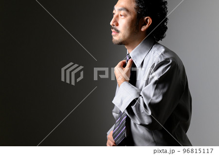 ダンディな髭の男性がネクタイをしめるところ 96815117