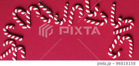 Christmas composition with frame of candy canes on red background. Copy space for text. banner Christmas composition with frame of candy canes on red background. Copy space for text. banner 96818158