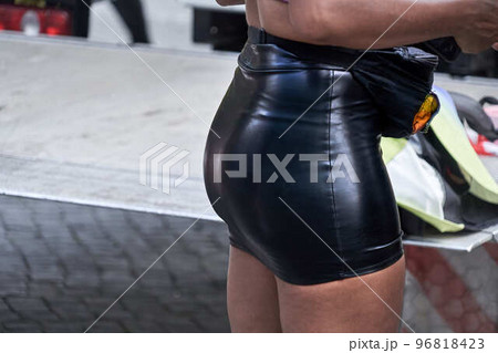 Short black latex pants fits tightly to the back of a person Short black latex pants fits tightly to the back of a person 96818423