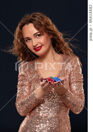 Casino concept. Portrait of young pretty caucasian woman, playing in casino. Roulette, poker chips, cards, wheel, black background 96818882