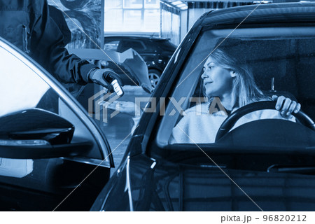 Mechanic giving car keys to female customer after servicing 96820212