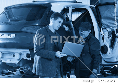 Auto mechanic and technician working in repair shop 96820323