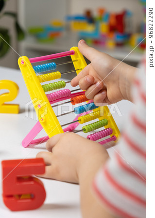 A small child learns to count on abacus, mathematics, arithmetic for children. 96822290