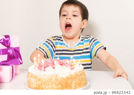 The birthday boy blows out the candles on the birthday cake The birthday boy blows out the candles on the birthday cake 96822342