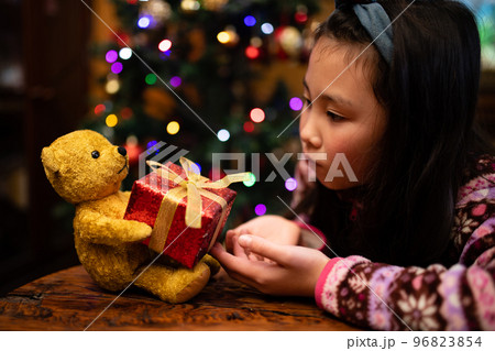 熊の縫いぐるみからクリスマスプレゼントを受け取る子供 96823854