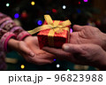 クリスマスプレゼント手渡す老人と孫娘の手 96823988
