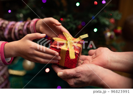 クリスマスプレゼント手渡す老人と孫娘の手 96823991