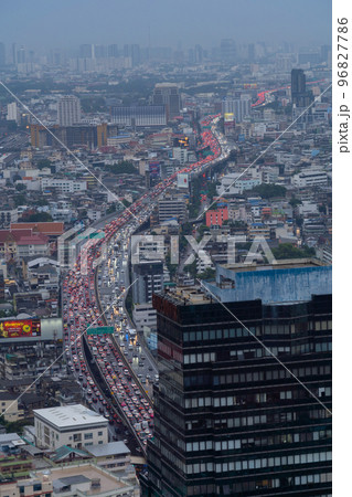 Aerial view of busy cars with traffic jam in the rush hour on highway road street on bridge in Bangkok Downtown, urban city in Asia, Thailand at sunset. Intersection junction. Toll gate in Rama 9 Aerial view of busy cars with traffic jam in the rush hour on highway road street on bridge in Bangkok Downtown, urban city in Asia, Thailand at sunset. Intersection junction. Toll gate in Rama 9 96827786