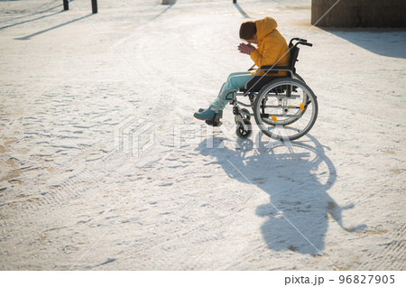 Woman crying in wheelchair outdoors in winter. Woman crying in wheelchair outdoors in winter. 96827905