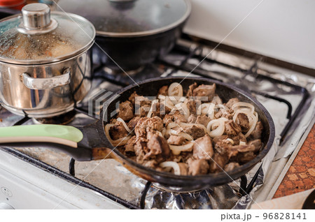 Fried veal liver with onions in a pan. Braised cow and pork liver 96828141