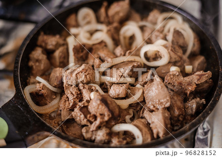 Fried veal liver with onions in a pan. Braised cow and pork liver 96828152