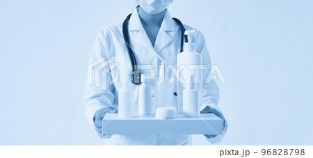 Doctor holding many bottles of hand sanitizers and liquid soap on black background 96828798