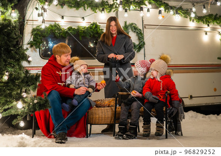 Happy Caucasian family celebrating Christmas outdoors. Parents and three sons travel in a camper.  96829252