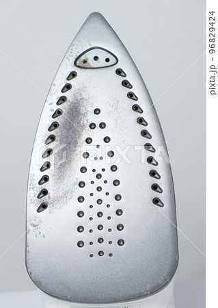 Damaged sole of the iron, brown stains and traces of burning with smoke and steam. Improper behavior during ironing clothes Damaged sole of the iron, brown stains and traces of burning with smoke and steam. Improper behavior during ironing clothes 96829424