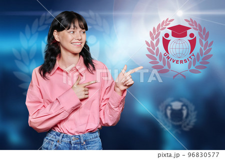 Teenage girl pointing with her hand at symbol of university 96830577
