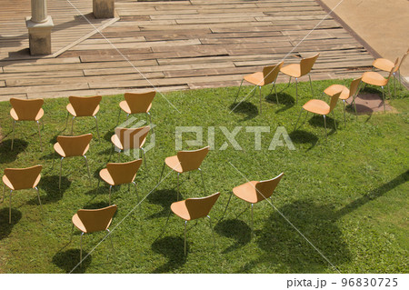 separate chairs on the lawn set up for a covid restricted celebration 96830725