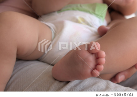 close-up of a foot of a baby on a lap of his father 96830733
