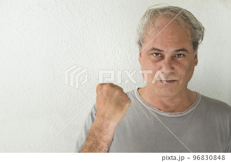 mature man looking at camera with raised fist in victory sign on white background mature man looking at camera with raised fist in victory sign on white background 96830848