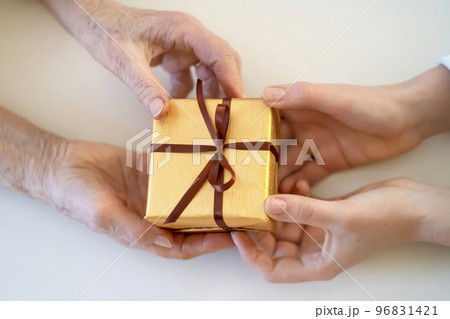 Female hands hold and give a nice packed gift. Female hands hold and give a nice packed gift. 96831421