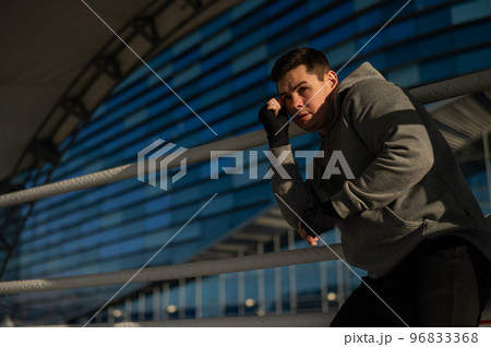 A man in a hoody trains in boxing at the stadium. A man in a hoody trains in boxing at the stadium. 96833368