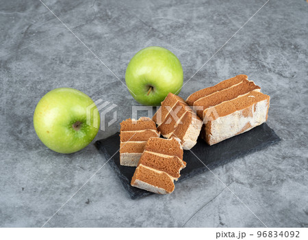 Apple pastille chopped into pieces on a stone serving board. Apple pastille chopped into pieces on a stone serving board. 96834092