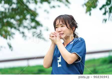 不安な気持ちで祈るように日本代表を応援するサッカーファン・サポーターの日本人女性 96836941