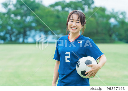 サッカーボールを持ちながら笑顔でサッカーするファン・サポーターの日本人女性 96837148