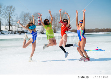 Four Caucasian women in swimsuits are fooling around on a snowy beach. Winter fun. 96838408