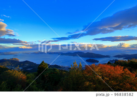 秋の夕暮れ時に 更に赤く染まる紅葉した木々 96838582