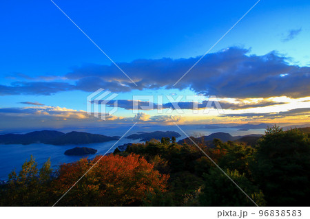 秋の夕暮れ時に 更に赤く染まる紅葉した木々 96838583