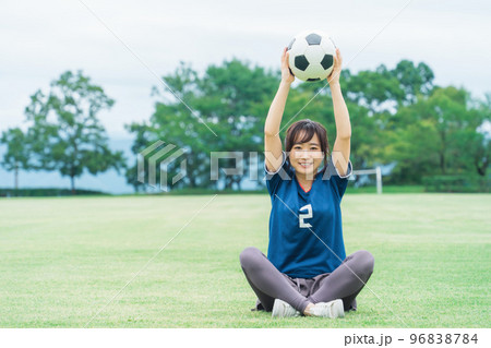 運動場でサッカーボールを持つサッカーファン・サポーターの日本人女性 96838784