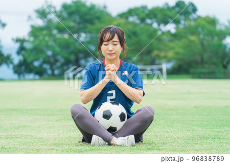 祈るように日本代表を応援するサッカーファン・サポーターの日本人女性 96838789