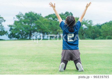 サッカー場でフットサル・サッカーで勝利して喜ぶサッカー選手の女性 96839765