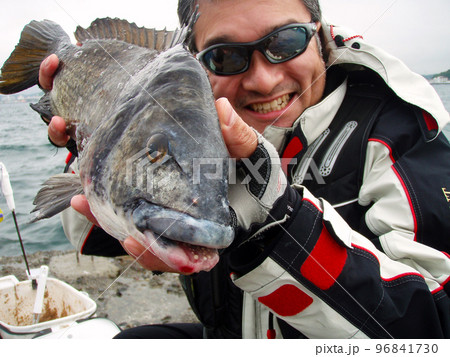 年無し50cmオーバーの黒鯛を手に満面の笑みを浮かべる磯釣りアングラー。 年無し50cmオーバーの黒鯛を手に満面の笑みを浮かべる磯釣りアングラー。 96841730