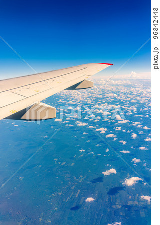 View from the airplane window at a beautiful cloudy sky and the airplane wing View from the airplane window at a beautiful cloudy sky and the airplane wing 96842448
