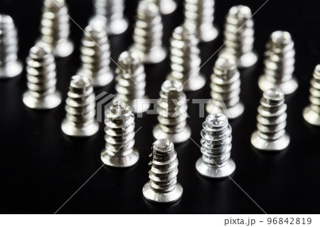 A group of Small bolts for computer equipment and computer assembly on black background 96842819