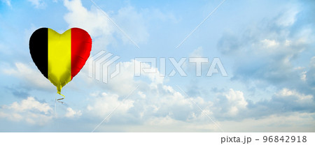 Flag of Belgium on heart-shaped balloon against sky clouds background. Flag of Belgium on heart-shaped balloon against sky clouds background. 96842918