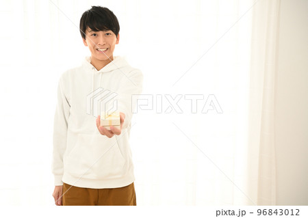 プレゼントの箱の包みを差し出す若い男性 プレゼントの箱の包みを差し出す若い男性 96843012