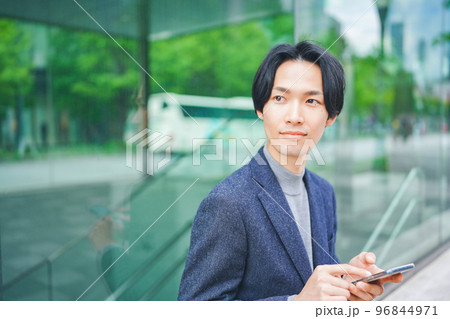 オフィス街でスマートフォンを操作する男性 96844971