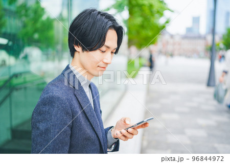 オフィス街でスマートフォンを操作する男性 オフィス街でスマートフォンを操作する男性 96844972