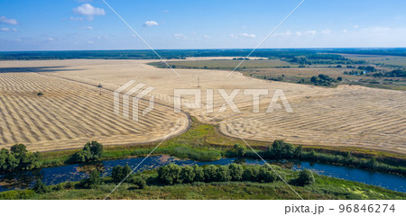 aerial photography of a bend in a river flowing through mown fields 96846274